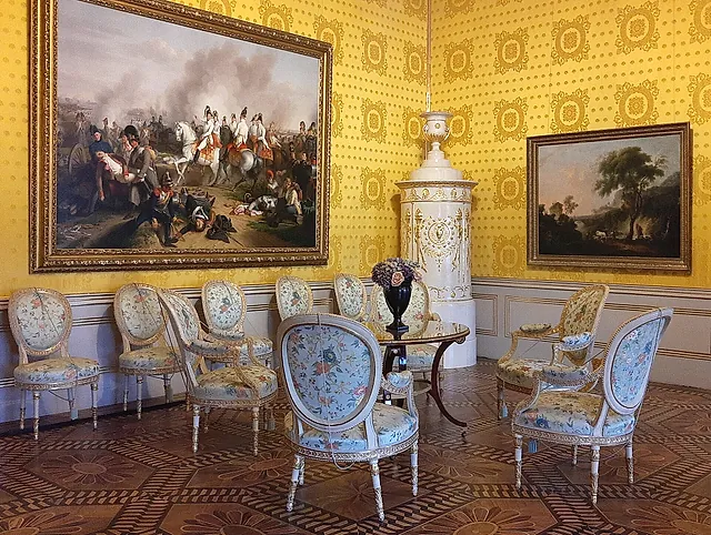 One of the Habsburg State Rooms of the Albertina, a yellow room with a stove and chairs