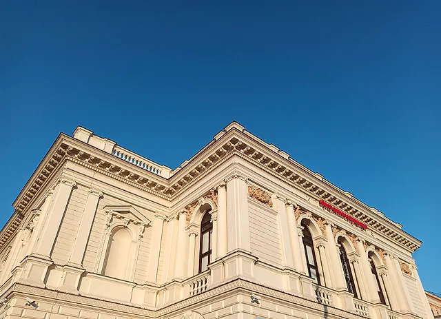 A corner of Albertina Modern seen from below against a blue sky