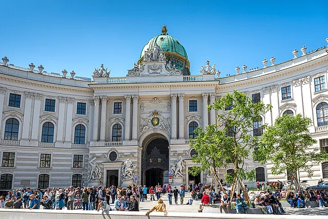 The domed Michaelertor wing of the Hofburg on Michaelerplatz, under a blue sky